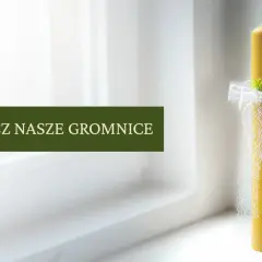 Piękna, prawdziwa gromnica ozdobiona białymi wstążkami i zielonymi gałązkami, gotowa na uroczystość.
