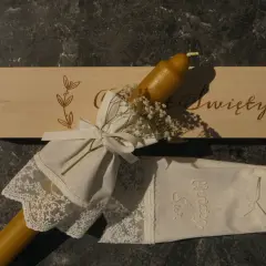 Eleganckie gromnice z wosku pszczelego, ozdobione koronką i wstążką, gotowe na uroczystość.