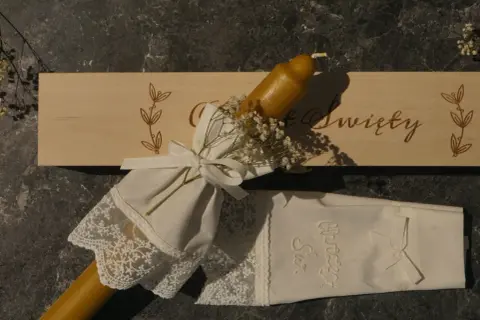 Eleganckie gromnice z wosku pszczelego, ozdobione koronką i wstążką, gotowe na uroczystość.