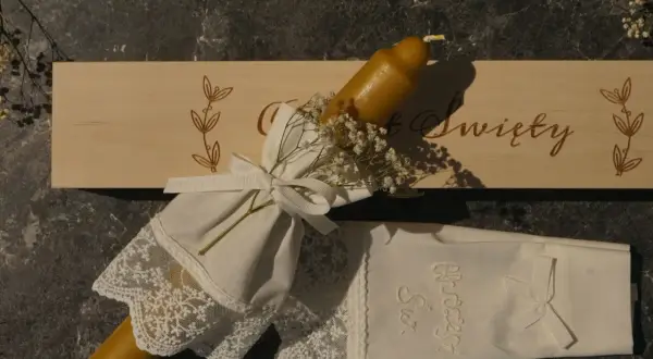 Eleganckie gromnice z wosku pszczelego, ozdobione koronką i wstążką, gotowe na uroczystość.