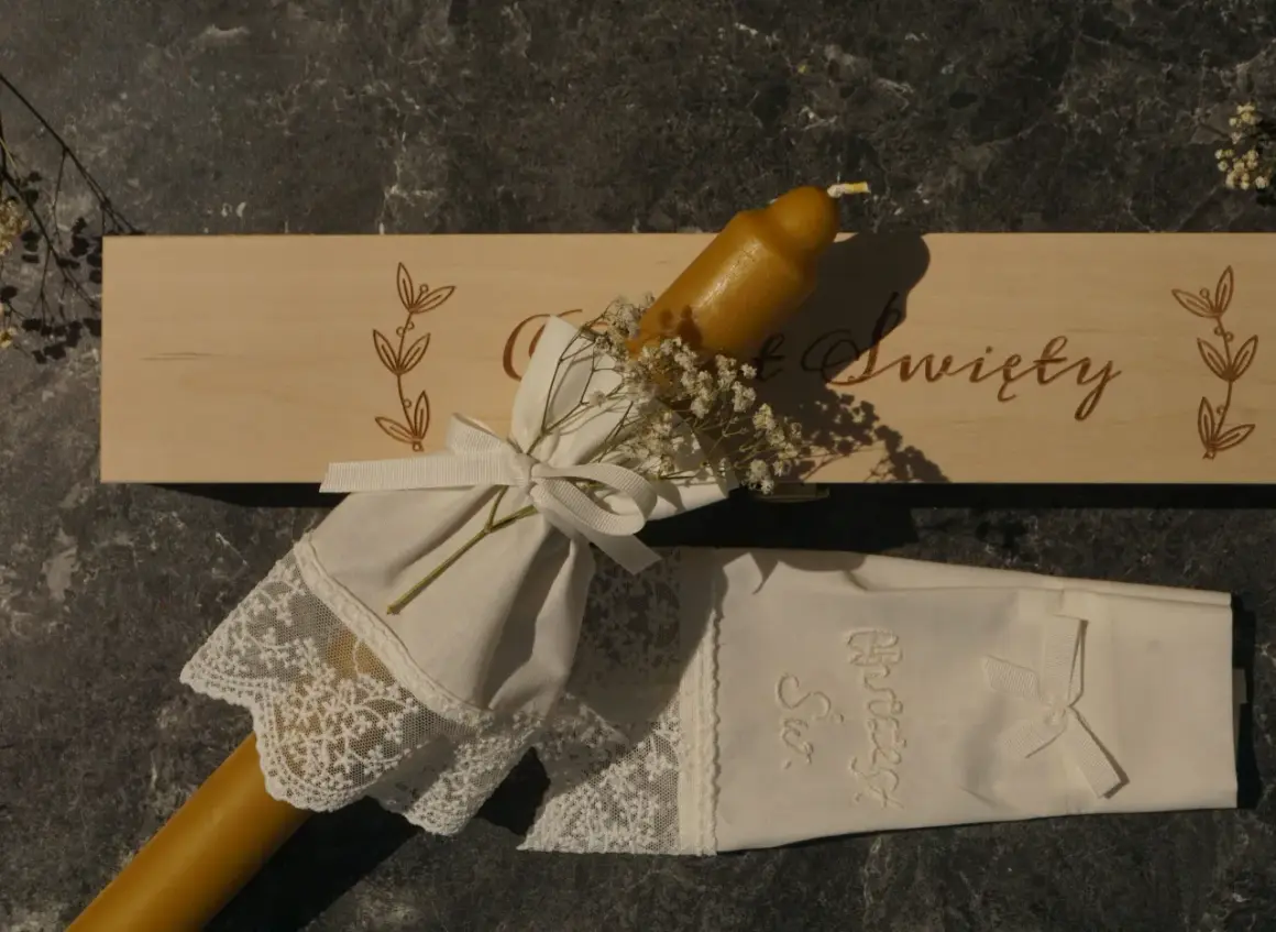 Eleganckie gromnice z wosku pszczelego, ozdobione koronką i wstążką, gotowe na uroczystość.